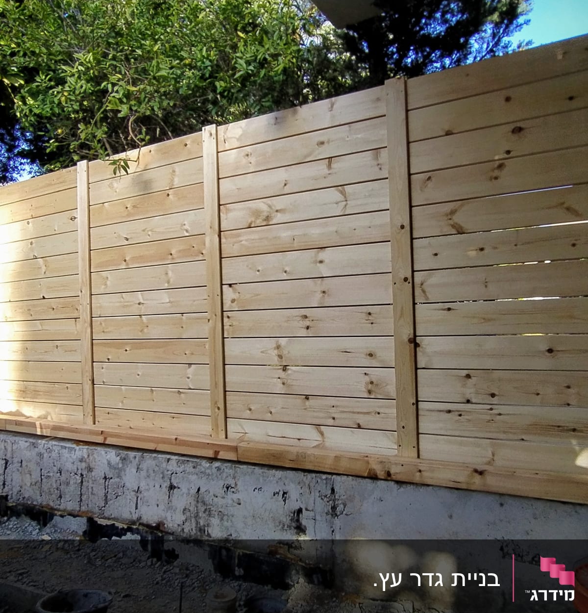 גדר עץ חדשה מותקנת בגינה עם קרקע חשופה